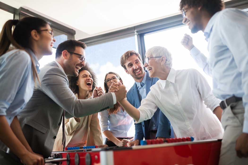 Multiracial people having fun in office room, excited diverse employees enjoying activity at work